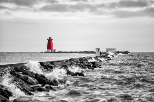 A high Spring tide at The Great South Wall and Poolbeg Lighthouse as waves lap over the pier.