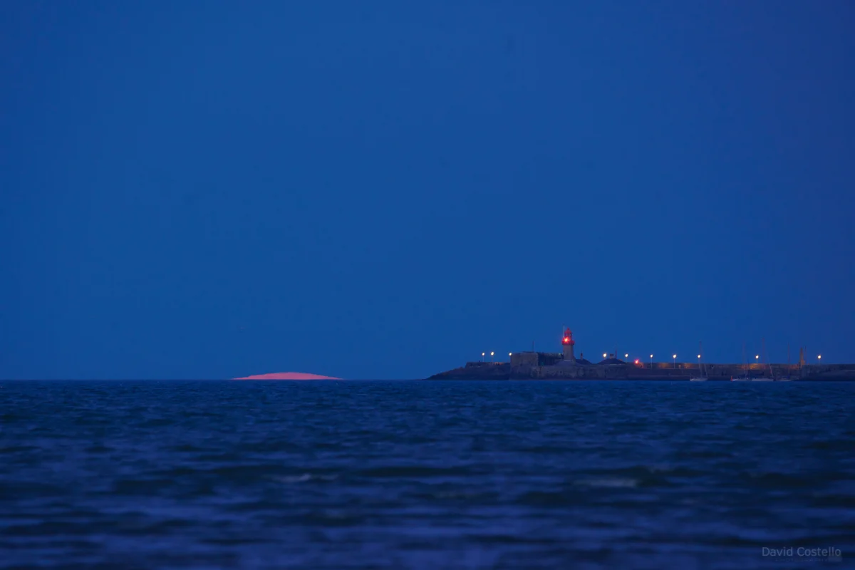 The tip of the Supermoon appearing from Dublin Bay.