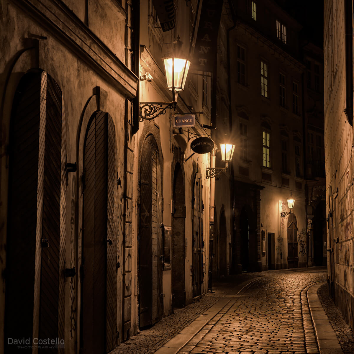 A quiet night scene in the bustling city of Prague, along this 14th century street a warm glow from the vintage street lamps hid the cold February night from view.