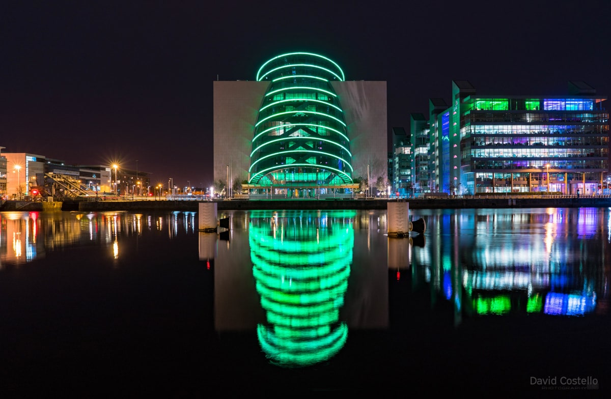 The Convention Centre lit in green for the Easter rising centenary reflecting in the placid river Liffy.