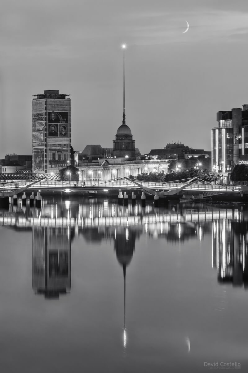 The Spire and The Custom House aligned, Liberty Hall and also the crescent moon setting, all reflecting in the river Liffey.
