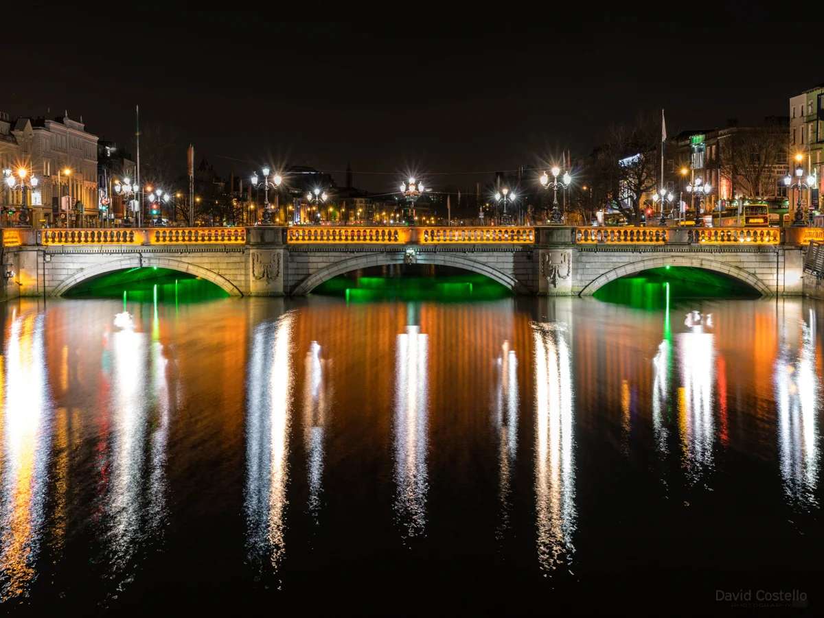 O'Connell Bridge lit in green, white and orange for the centenary of the 1916 Easter rising, reflections on the river Liffey.