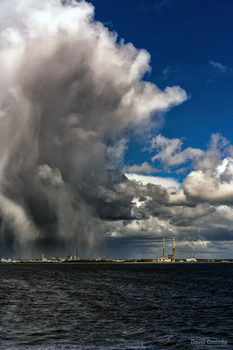 A line of hail and sunshine divides the Dublin sky as a spring storm rolls through the bay towering over the Poolbeg Chimneys