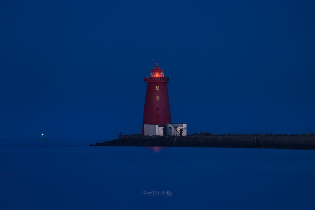 Poolbeg Lighthouse glows against the midnight blues of a summer night in Dublin Bay.
