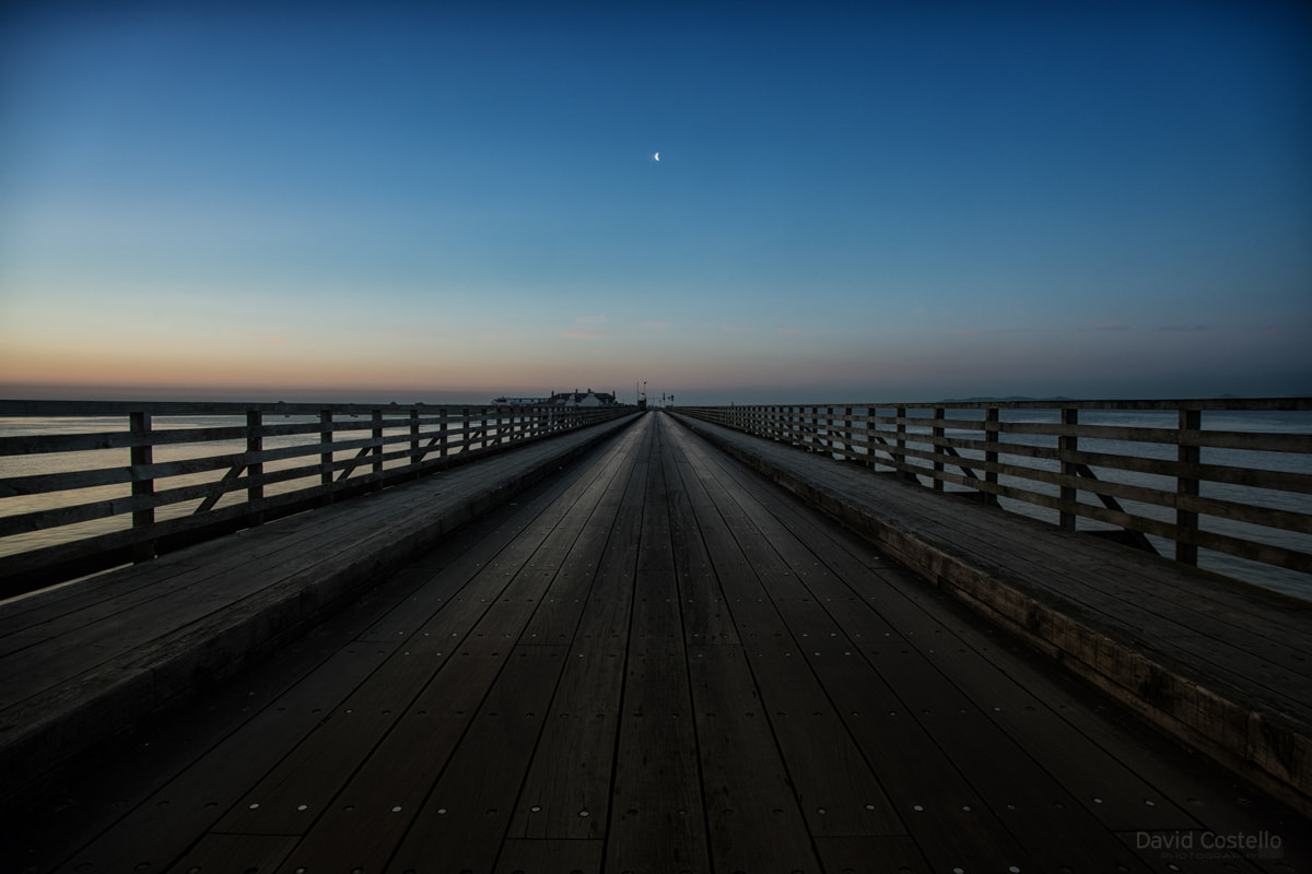The Wooden Bridge in Clontarf at sunrise as the half moon aligns along it early on a beautiful summer morning.