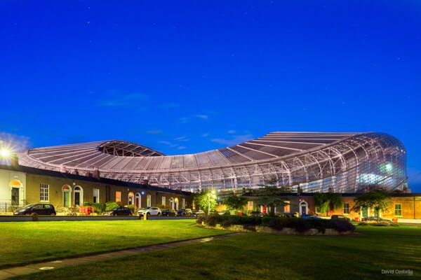 Aviva Stadium illuminated at twilight overlooking Havelock Square.