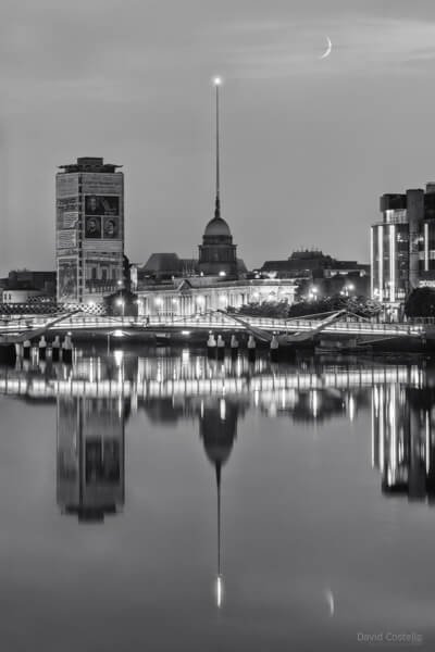 The Custom House, Liberty Hall, The Spire and a Crescent Moon all reflect in a perfectly calm river Liffey.
