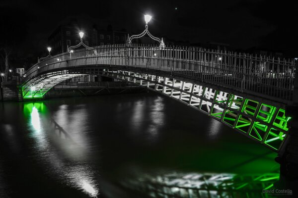 The Ha'penny Bridge with green lighting for St.Patrick's Day festivities in Dublin.