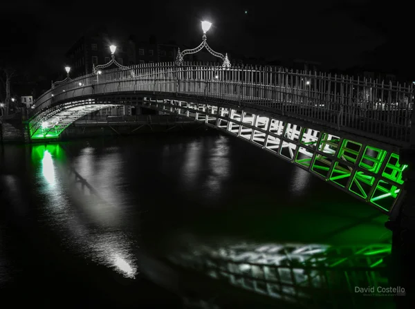 The Ha'penny Bridge with green lighting for St.Patrick's Day festivities in Dublin.