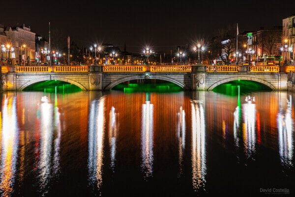 O'Connell Bridge with green, white and orange lighting for St. Patrick's Day in Dublin.