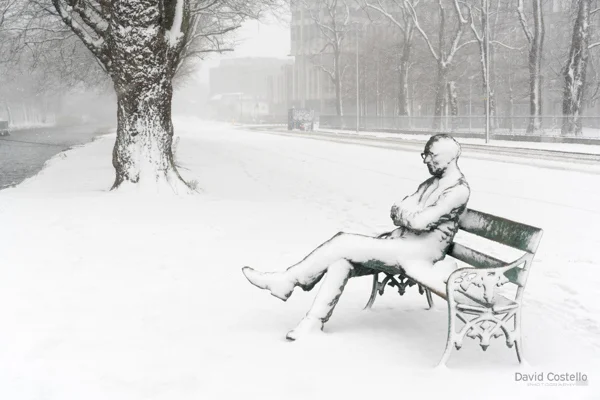 The statue of Patrick Kavanagh covered in Snow along with the Grand Canal walkway in Dublin.