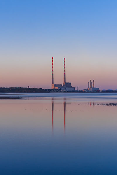 A beautiful April evening along Sandymount Strand looking across the calm tide towards the Poolbeg Chimneys at sunset.
