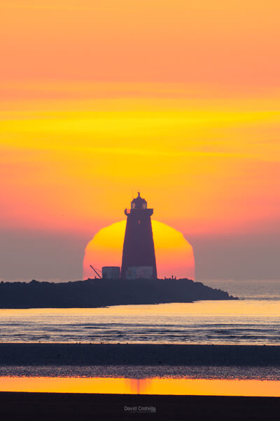 A soft pastel sunrise illuminates Poolbeg Lighthouse