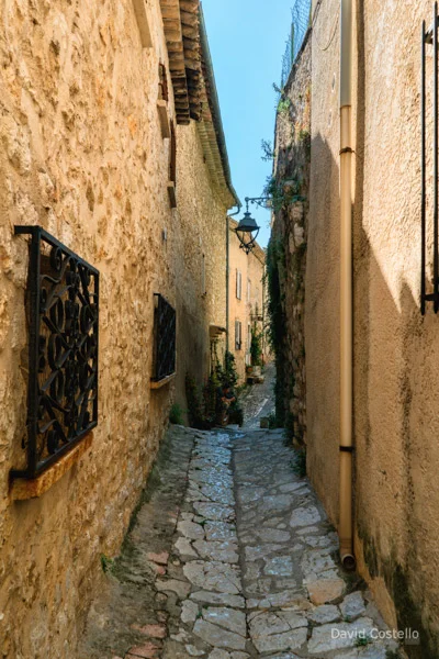 A very narrow cobblestone walkway with a lantern hanging in Saint-Paul de Vence.