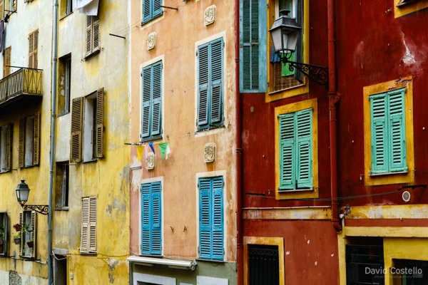 Colourful and worn walls and louvre shutters in Nice, France.