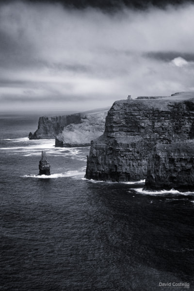 Standing on the Cliffs of Moher looking towards O'Brien's Tower and the cliff faces below the tower down to the sea.