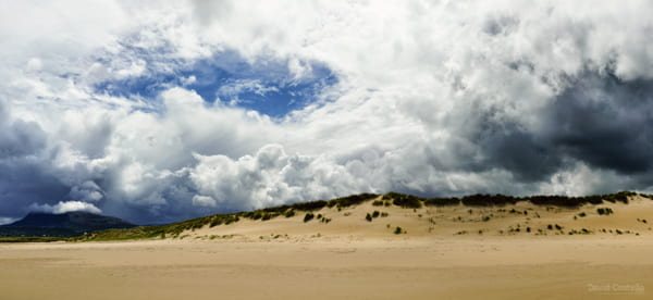 The sun hits the sand dunes of Falcarragh Beach (Back Strand Beach) as a storm rolls in from the south.