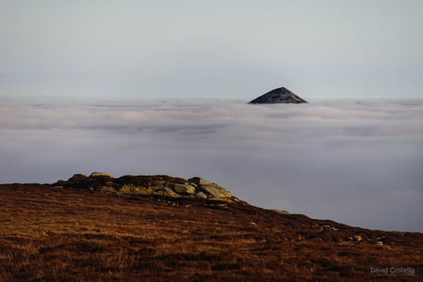 The Sugarloaf Mountain peak poking out from the thick fog that is covering the valleys below.